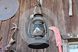 Old Lantern and Farm Tools On Cabin Wall