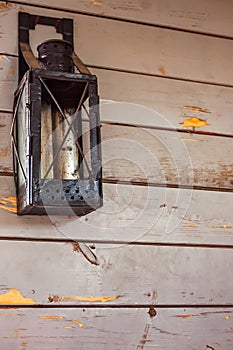 Old lantern hanging on the wooden wall