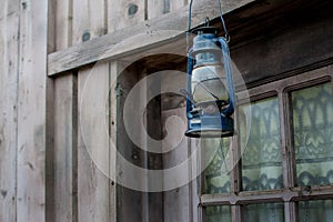 old lantern hangs against a background of blue boards