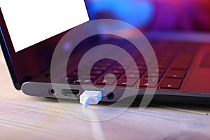 Old laptop with usb cable on table