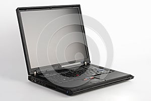 Old laptop on white background, which was produced in 2005, outer cover reinforced titanium, metal hinges, red trackpoint