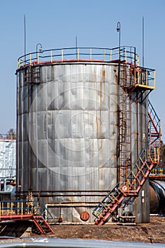 Old large rusted oil tank with stairs