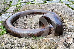 Old large rusty metal ring for mooring boats in the river