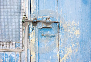 Old latch on a wooden blue door in Tuscany, Italy