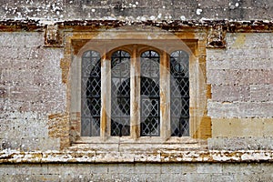 An old leaded window with a concrete frame in an old English country house