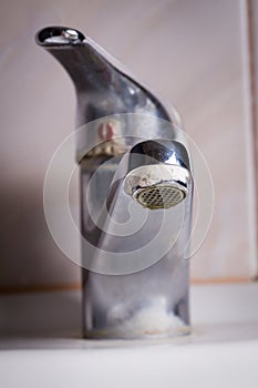 Old leaking faucet with stone and calcium sediments. photo