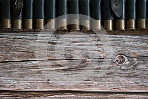 Old leather bandolier with cartridges close-up on a wooden background