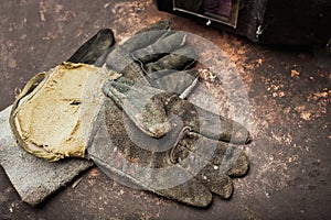 Old leather gloves for welders on rusty table