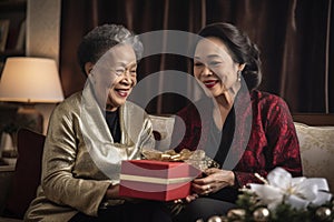 old lesbian middle aged couple giving gifts and presents to each other, female gay lgbt homosexual asian marriage or girlfriends
