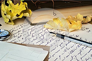 Old letter, pen, book and yellow leaves