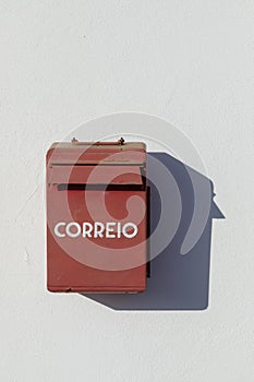 Old letterbox at a white painted wall with painted Correio - engl: postl photo