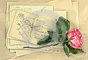 Old letters and dry rose flower. Vintage postcards and envelopes