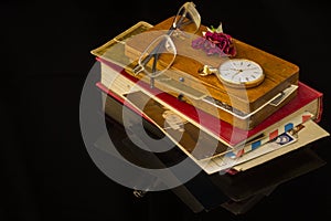 Old letters, glasses, dried rose, pocket watch all on a black background with blank space