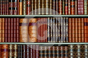 Old library of vintage hard cover books on shelves photo