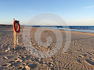 The old lifeline against the sea hangs on the beach with copy space