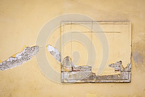 An old light brown wall with bricked windows