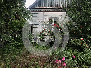 old light house with a fence of planks and flowers