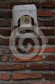 Old light switches in a red brick wall in Yogyakarta