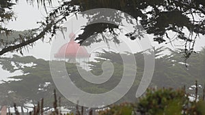 Old lighthouse fresnel lens glowing, foggy rainy weather. Illuminated beacon USA