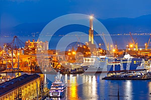 Old Lighthouse in port of Genoa at night, Italy.