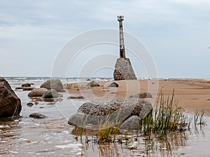 Old lighthouse on sandy beach, beautiful reflections in runoff water Kumrags lighthouse photo
