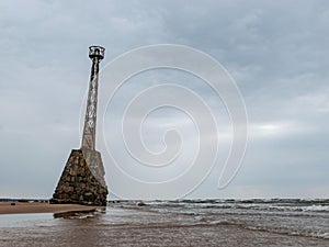 Old lighthouse on sandy beach, beautiful reflections in runoff water Kumrags lighthouse