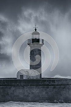 Old lighthouse and spray from stormy waves