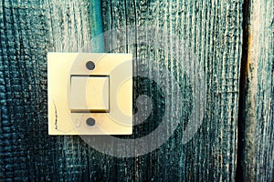 Old Lighting Switch on the wood wall. Close up hand turning on or off on grey light switch with wooden background. Copy space