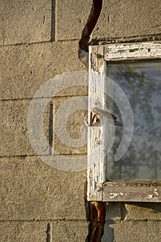 An old little window in the barn. Wooden window frame with glass and lock. The glass window in the barn is broken. The