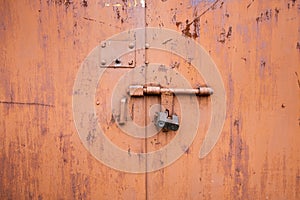 Old lock of the metal door. Rusty old metal texture with remnants of the paint.