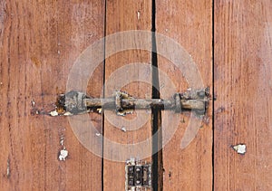 Old locked padlock rusty on the gate wooden door plank brown background