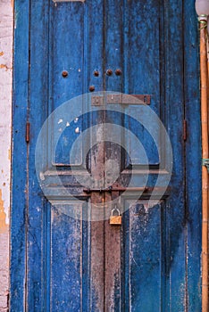 Old locked wooden door with an iron lock