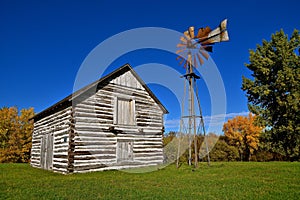 Old log building with a wind mill