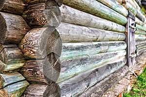 Old log cabin house, wood wall pattern close-up. Vintage wooden home exterior