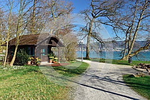 Old log house in Villette-park on the shore of lake Zug in spring. Town of Cham, canton of Zug, Switzerland.