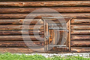 Old log house wood wall with closed door and padlock on it