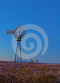 Old Lone Windmill Sits Still at Dusk with Mountain in the Background