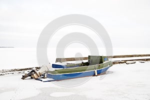 Viejo solitario motora en congelado puerto en el invierno 