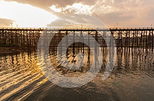 Old an long wooden bridge with sunset light at Sangklaburi