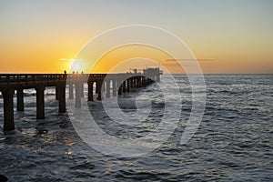 Old long wooden jetty at sunset