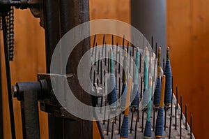 Old loom, spinning machine, rows of white and colored cotton threads