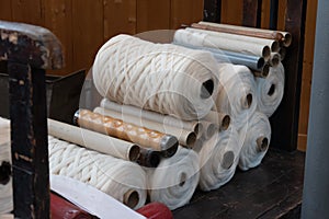 Old loom, spinning machine, rows of white and colored cotton threads