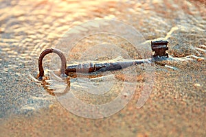 An old lost key in the sand is a newfound opportunity. The concept of success, luck and unexpected wealth