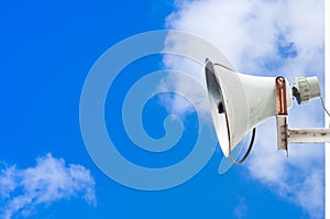 Old loudspeaker against cloudy blue sky