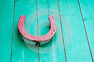 Old lucky horseshoe on red wooden wall.