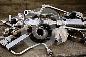 Old machine parts in machinery shop on wooden background