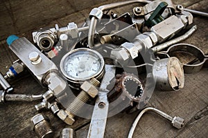 Old machine parts in machinery shop on wooden background