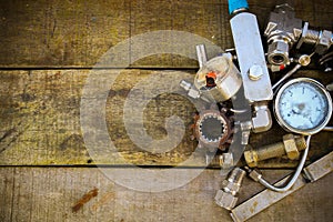 Old machine parts in machinery shop on wooden background