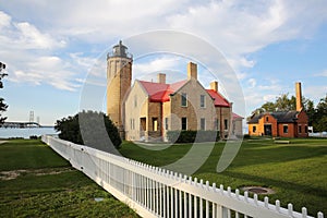 Old Mackinac Point Lighthouse at sunset time, with Mackinac Bridge in the background, Mackinaw City, Michigan, USA