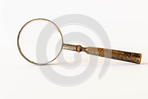 An old magnifying glass on a light background. The concept of information search. Selective focus